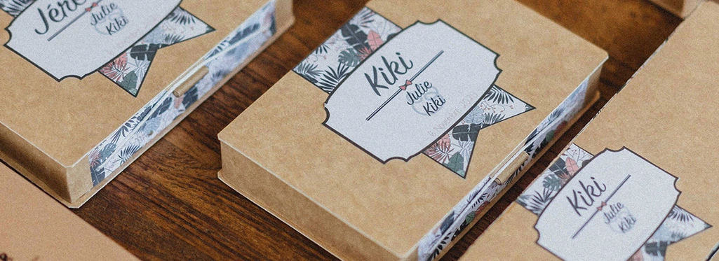 Boîtes en carton avec étiquettes personnalisées sur une table en bois.