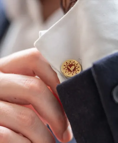 Bouton de manchette doré avec motif de cœur sur chemise blanche.